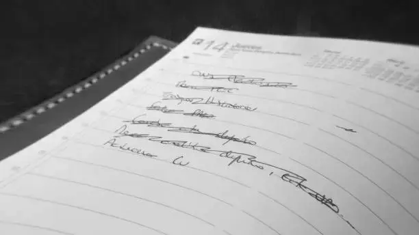Handwriting in a spiral notebook, several lines crossed out